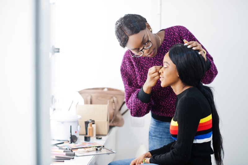 Cosmetology student practicing hair styling techniques in beauty school training salon